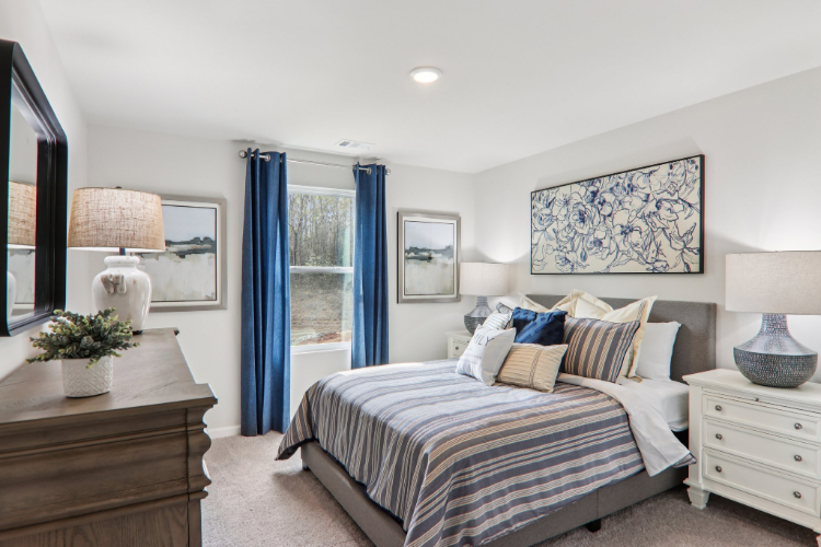 A bedroom with a bed and blue curtains.