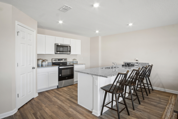 A kitchen with white cabinets.