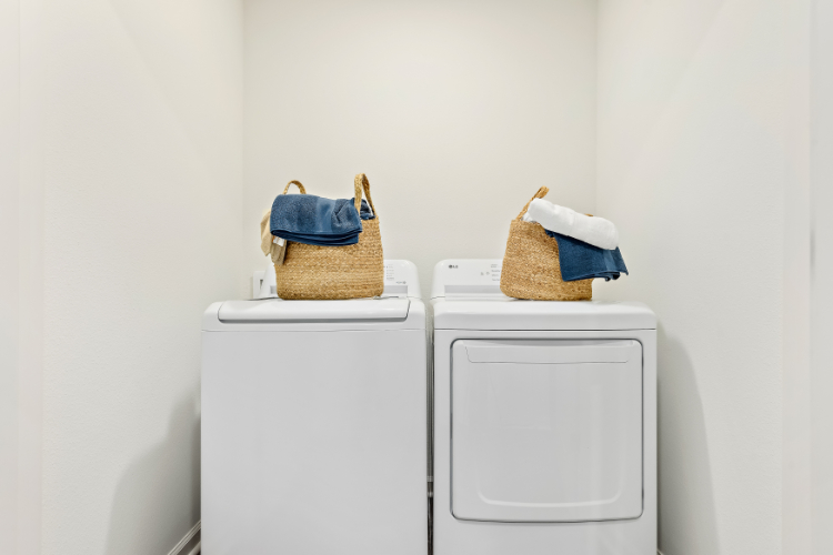 A couple of baskets on top of a dryer.