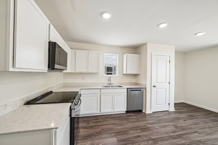 A kitchen with white cabinets.