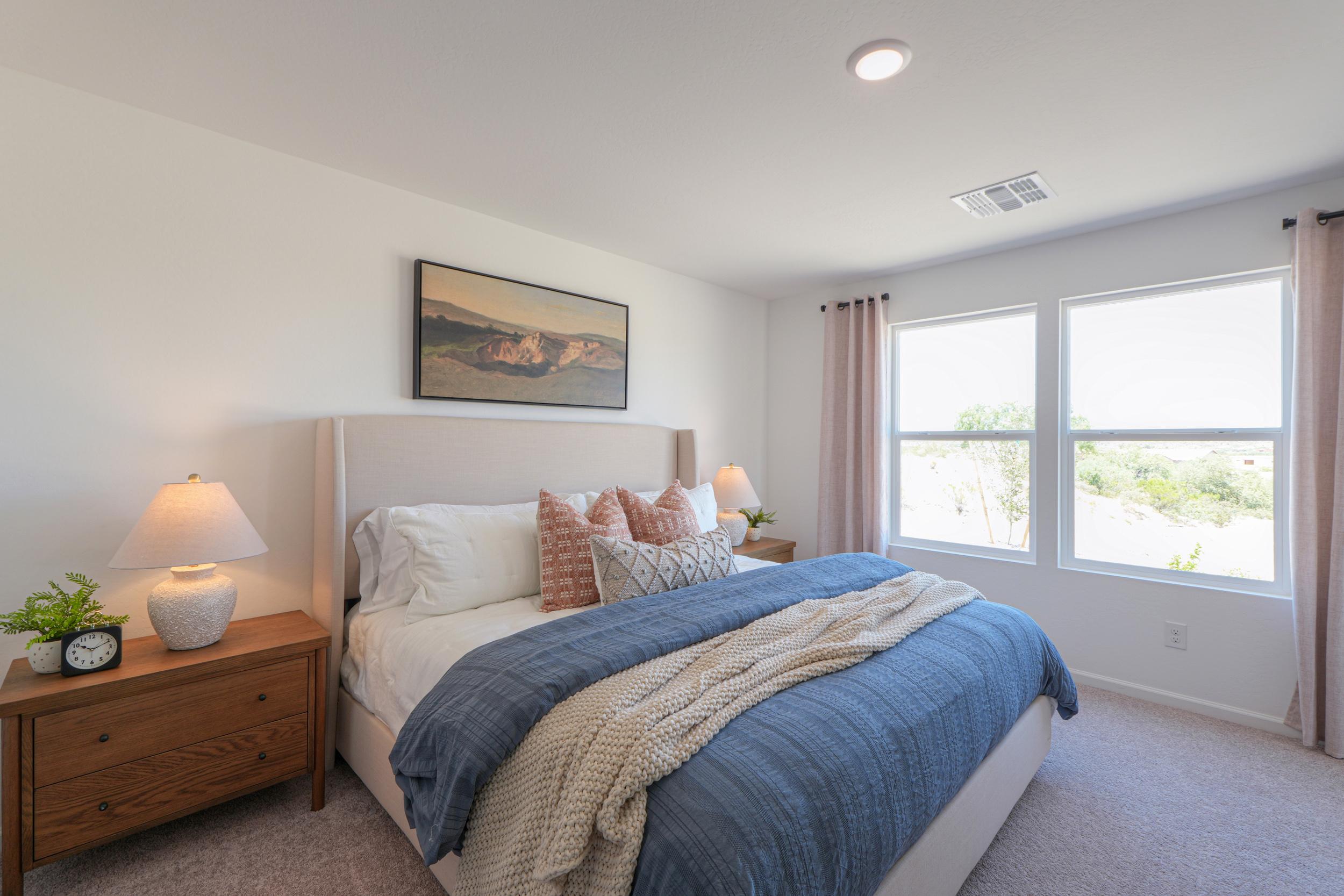 A bedroom with a bed and a lamp.