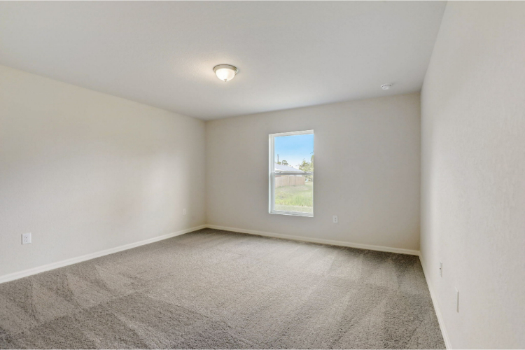 A room with a window and carpet.