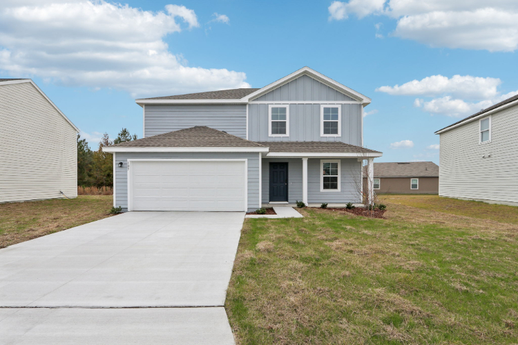 A house with garages and grass.
