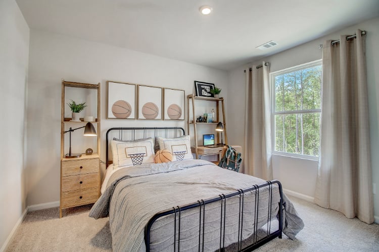 A bedroom with a bed and a shelf with a window.