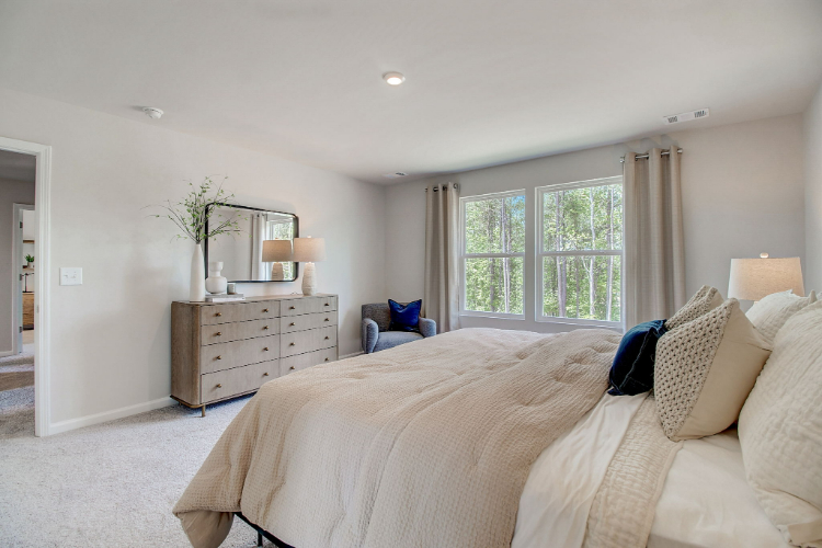 A bedroom with a bed and a dresser.