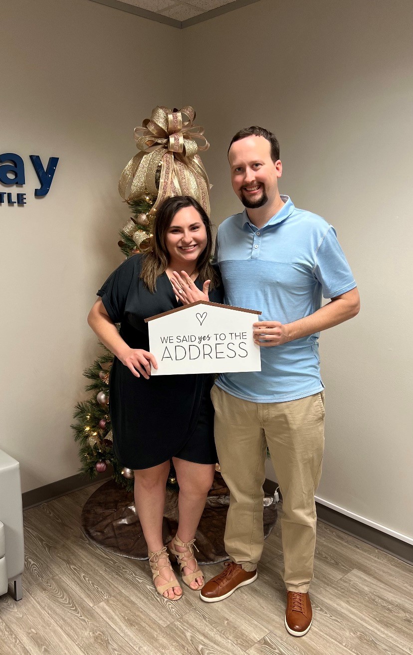 A man and woman holding a sign.